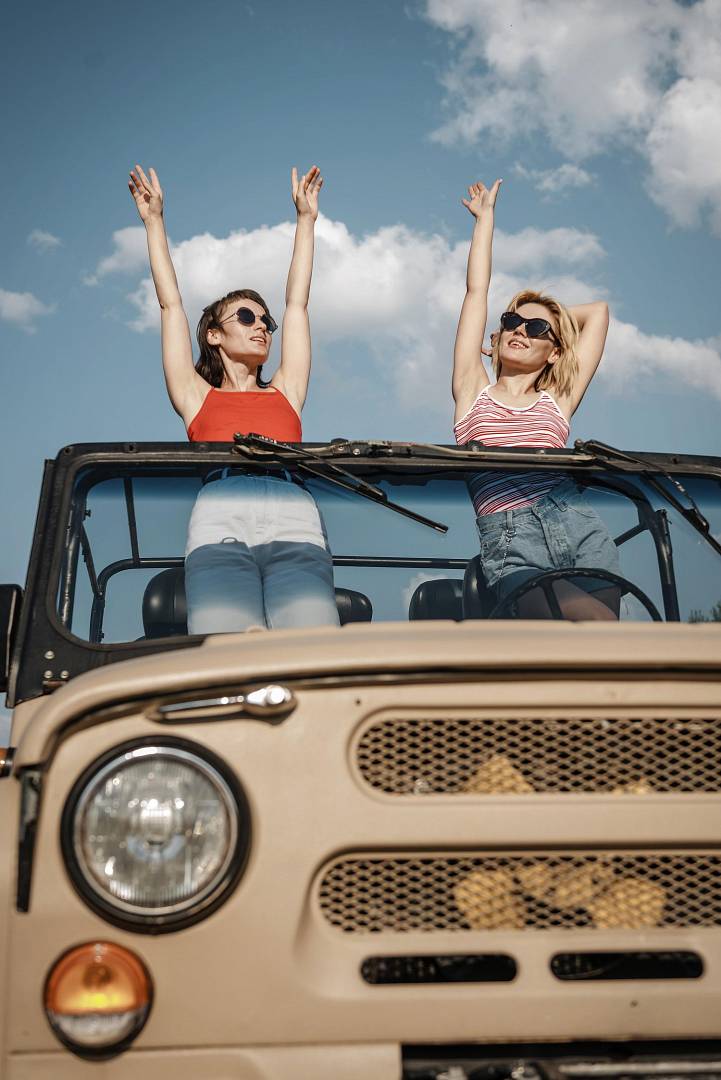 front-view-two-women-having-fun-while-traveling-by-car.jpg